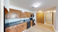 This 2-bedroom, 2-bathroom residence at 2900 River Dr in Moline, Illinois offers a thoughtfully designed single-floor layout that balances comfort and functionality. Light-toned laminate wood flooring flows consistently throughout the unit, lending a clean and cohesive aesthetic to every room.

The kitchen is efficiently designed with warm honey-toned cabinetry, dark countertops, and a full suite of black appliances including a refrigerator, gas range, built-in microwave, and dishwasher. Ample upper and lower cabinet storage maximizes utility in the space.

The open living area adjoins the kitchen, providing a bright and versatile space with neutral gray walls and multiple windows that invite natural light. The spacious primary bedroom features two closets with built-in shelving and drawers, a ceiling fan, and windows with exterior views. The second bedroom is comparably sized with a window and built-in climate control unit.

Both bathrooms are consistently finished with warm wood vanities, white countertops, tile flooring in a subtle linear pattern, large mirrors, and chrome fixtures. The clean, minimalist design carries throughout both bathrooms, one of which includes accessible grab bars.

Overall, this residence presents a clean, move-in-ready environment with consistent finishes and practical amenities throughout.
