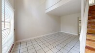 Located in Miami's vibrant Coconut Grove neighborhood, this two-story, 1-bedroom, 2-bathroom home offers a practical and well-organized layout spread across two floors. The main level hosts the primary living spaces, including a combined living and dining room finished with clean white tile flooring that reflects ample natural light. The galley-style kitchen is thoughtfully equipped with white cabinetry, butcher block countertops, open shelving, a patterned tile backsplash, stainless steel appliances, and a window that brings in natural light. Two closets and a staircase provide convenient storage and access between levels. The upper floor features light wood laminate flooring throughout, lending warmth to the bedroom and landing area. A window on the upper level allows natural light to filter in, creating a bright and airy atmosphere. Two bathrooms serve the home, one of which includes a tiled tub-shower combination with chrome fixtures and a frosted window. The space is finished with crisp white walls and clean trim throughout, giving it a bright, neutral aesthetic. Surrounded by mature trees as seen from the exterior, this home sits within easy reach of Coconut Grove's shops, dining, and waterfront attractions.