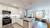 This well-appointed 1-bedroom, 2-bathroom residence in Grand Prairie, TX offers a thoughtfully designed single-story layout that maximizes both comfort and functionality. The open-concept kitchen is a standout feature, showcasing white shaker cabinetry, subway tile backsplash, granite countertops, stainless steel appliances, and a large center island with pendant lighting and bar seating — flowing seamlessly into the dining and living areas. The living room is bright and welcoming, benefiting from natural light through large windows and a relaxed, neutral aesthetic. The dedicated dining area is conveniently positioned adjacent to an in-unit laundry closet, adding everyday practicality. A separate office provides a quiet workspace distinct from the main living areas. The generously sized primary bedroom features plush carpeting, a ceiling fan, natural light, and an outdoor view of the pool area. The en-suite primary bathroom offers a granite-topped double vanity, walk-in shower with glass enclosure, and wood-look tile flooring. Two spacious closets, including a well-organized walk-in, provide ample storage throughout. Wood-look flooring runs through the main living spaces, tying the home's clean, modern design together cohesively.