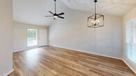 This single-story, 2-bedroom, 2-bathroom home in Greenville, Texas offers a thoughtfully designed layout with modern finishes throughout. The open living area immediately impresses with soaring vaulted ceilings, warm hardwood-style flooring, and an eye-catching geometric chandelier paired with a ceiling fan. Natural light pours in through large windows, creating a bright and inviting atmosphere, while a front entry door adds convenience and accessibility.

The kitchen is a standout feature, showcasing slate-blue shaker-style cabinetry reaching to the ceiling, crisp white quartz countertops, stainless steel appliances, and a sleek undermount sink with a matte black faucet. A peninsula connects the kitchen to the living and dining areas, making it ideal for everyday living.

Both bedrooms are generously sized, each equipped with ceiling fans and hardwood-style flooring. The primary bedroom benefits from vaulted ceilings and ample natural light. Each bedroom is served by a dedicated bathroom — one featuring dark cabinetry, a white quartz vanity, matte black fixtures, and a glass-enclosed tub/shower combo, and the other offering a soaking tub. Each bedroom also includes its own closet. The home's clean, neutral palette and modern hardware selections create a cohesive and contemporary living environment throughout.