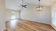This single-story, 2-bedroom, 2-bathroom home in Greenville, Texas offers a thoughtfully designed layout with modern finishes throughout. The open living area immediately impresses with soaring vaulted ceilings, warm hardwood-style flooring, and an eye-catching geometric chandelier paired with a ceiling fan. Natural light pours in through large windows, creating a bright and inviting atmosphere, while a front entry door adds convenience and accessibility.

The kitchen is a standout feature, showcasing slate-blue shaker-style cabinetry reaching to the ceiling, crisp white quartz countertops, stainless steel appliances, and a sleek undermount sink with a matte black faucet. A peninsula connects the kitchen to the living and dining areas, making it ideal for everyday living.

Both bedrooms are generously sized, each equipped with ceiling fans and hardwood-style flooring. The primary bedroom benefits from vaulted ceilings and ample natural light. Each bedroom is served by a dedicated bathroom — one featuring dark cabinetry, a white quartz vanity, matte black fixtures, and a glass-enclosed tub/shower combo, and the other offering a soaking tub. Each bedroom also includes its own closet. The home's clean, neutral palette and modern hardware selections create a cohesive and contemporary living environment throughout.