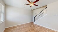 Located at 1501 Flatwood St in Murrells Inlet, SC, this two-bedroom, two-bathroom two-story home offers a well-organized layout across two floors. The main level is the most expansive, housing the open-concept kitchen and living area. The kitchen is a standout feature, showcasing crisp white shaker cabinetry, granite countertops, a center island with pendant lighting, and a full suite of stainless steel appliances including a refrigerator, range, microwave, and dishwasher. Natural light pours in through multiple windows fitted with blinds. Warm hardwood-style flooring extends throughout the main level, complemented by ceiling fans in the living areas. A staircase with a classic white baluster and dark handrail connects the main floor to the upper level. The bedrooms offer ceiling fans, windows with natural light, and ample closet space — including a walk-in closet with wire shelving. The second bedroom on the upper level features soft carpeting and a double-door closet. Both bathrooms are clean and functional, with one featuring a tub-shower combination. The home's neutral color palette and consistent finishes create a cohesive, move-in-ready atmosphere throughout.
