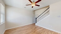 Located at 1501 Flatwood St in Murrells Inlet, SC, this two-bedroom, two-bathroom two-story home offers a well-organized layout across two floors. The main level is the most expansive, housing the open-concept kitchen and living area. The kitchen is a standout feature, showcasing crisp white shaker cabinetry, granite countertops, a center island with pendant lighting, and a full suite of stainless steel appliances including a refrigerator, range, microwave, and dishwasher. Natural light pours in through multiple windows fitted with blinds. Warm hardwood-style flooring extends throughout the main level, complemented by ceiling fans in the living areas. A staircase with a classic white baluster and dark handrail connects the main floor to the upper level. The bedrooms offer ceiling fans, windows with natural light, and ample closet space — including a walk-in closet with wire shelving. The second bedroom on the upper level features soft carpeting and a double-door closet. Both bathrooms are clean and functional, with one featuring a tub-shower combination. The home's neutral color palette and consistent finishes create a cohesive, move-in-ready atmosphere throughout.