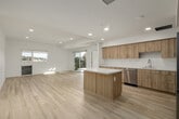 Unit 402 at 4210 Spring St in La Mesa, California offers a clean, modern design characterized by crisp white walls, light wood-style flooring, and an abundance of natural light throughout. The open-concept living and kitchen area serves as the heart of the unit, where warm wood cabinetry, white quartz countertops, a center island, and stainless steel appliances — including a refrigerator, dishwasher, and range — come together in a functional and stylish layout. Recessed lighting complements the natural brightness pouring in through large sliding glass doors. Those doors lead to a private balcony finished with a wood-beamed pergola overhead and black metal railings, offering sweeping panoramic views of La Mesa's rolling hills and the surrounding neighborhood skyline. The bedrooms are bright and well-proportioned, each benefiting from windows framing the same scenic hillside views, with light-toned flooring continuing throughout. A walk-in closet provides generous storage. The bathroom features a full soaking tub and shower combination with clean white tile surround, a wood-finish vanity, and a lighted mirror. An in-unit stacked washer and dryer adds everyday convenience. The overall ambiance is fresh, airy, and move-in ready.