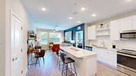 Located at 741 Clay St in Winter Park, FL, this well-appointed 2-bedroom, 2-bathroom residence offers a thoughtfully designed single-level layout. The open-concept living and kitchen area serves as the heart of the home, anchored by a bold teal accent wall and large windows that flood the space with natural light and views of lush greenery outside. Ceiling fans add comfort throughout the main living areas and bedrooms.

The kitchen is sleek and functional, featuring flat-front white cabinetry extending to the ceiling, stainless steel appliances including a French door refrigerator, over-the-range microwave, and electric range, complemented by clean white quartz countertops and a breakfast bar island with bar seating.

Both bedrooms are generously proportioned, each with large windows, ceiling fans, and light wood-tone flooring. The primary bedroom benefits from a private teal accent wall and serene outdoor views.

The two bathrooms are distinctly styled: one features a soaking tub with a decorative tiled surround and an extended vanity, while the second offers a glass-enclosed walk-in shower with white tile, paired with a sleek single-sink vanity. In-unit laundry adds everyday convenience, and five closets provide ample storage throughout the residence.