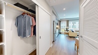 Located at 110 Constitution Dr in Menlo Park, California, this thoughtfully designed studio unit makes efficient use of its single-floor layout. The open-plan living space seamlessly integrates the sleeping, lounging, and dining areas, all unified by warm wood-tone flooring and recessed lighting throughout. Large windows invite an abundance of natural light and offer views of the surrounding courtyard, creating a bright and airy ambiance.

The kitchen is modern and well-appointed, featuring light wood cabinetry, white tile backsplash, a full suite of stainless steel appliances — including a French door refrigerator, electric range, over-the-range microwave, and dishwasher — and clean white countertops. A compact dining area positioned beside the window provides a comfortable space for meals.

The hallway features a built-in sliding-door closet offering generous storage, while connecting the main living area to the bathroom. The bathroom is a standout element, showcasing striking blue and gold wave-patterned tile that extends across the walls, a glass-enclosed walk-in shower, white tile flooring, and a clean vanity — combining artistic design with practical functionality.

Overall, the unit presents a cohesive, contemporary aesthetic suited for comfortable single-occupant living in the heart of Menlo Park.
