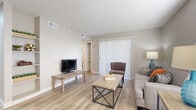 This 530 square foot apartment in Phoenix, AZ, offers a thoughtful blend of style and functionality. The open-concept living area features light wood-look flooring and neutral walls, creating a bright, airy atmosphere. Large windows with vertical blinds allow natural light to flood the space.

The living room is furnished with a comfortable gray sofa, accented by colorful throw pillows, and complemented by a plush burgundy armchair. Modern industrial-style tables add a contemporary touch. The adjacent kitchen boasts sleek white cabinetry, stainless steel appliances, and ample counter space, ideal for culinary enthusiasts.

The primary bedroom, measuring 130 square feet, includes a queen-sized bed with a black metal frame, flanked by matching nightstands. Vibrant abstract artwork adorns the walls, adding a splash of color. The second bedroom, while compact, offers versatility as a guest room or home office.

The bathroom features a clean, white design with a combination tub-shower, modern fixtures, and wood-look flooring. Additional amenities include a separate laundry area and a walk-in closet with built-in shelving, maximizing storage in this efficient floor plan.

Throughout the apartment, ceiling fans and recessed lighting contribute to the overall comfort and modern aesthetic. This well-designed space proves that compact living can be both stylish and practical.