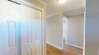 Located at 300 South St in Vernon Rockville, Connecticut, this one-bedroom, one-bathroom residence offers a thoughtfully designed single-floor layout. Warm hardwood-style flooring and crown molding carry throughout the space, lending a clean, cohesive aesthetic from room to room.

The galley-style kitchen is a standout feature, showcasing rich wood cabinetry, dark granite countertops, a stone tile backsplash, and stainless steel appliances including a range, refrigerator, microwave, and dishwasher — all set along parallel walls that maximize efficiency and storage.

The living room provides a comfortable gathering area with natural light filtering in, while the hallway connects the space with ease. The bedroom is generously sized, featuring a ceiling fan with light fixture, a wall-unit air conditioner, a large window with exterior views, and a dedicated closet with built-in storage. Crown molding continues in this room, maintaining the refined character found throughout.

The bathroom is outfitted with a full tub-and-shower combination, complete with built-in shelving for convenience. A dedicated in-unit laundry area houses a GE Profile washer and includes shelving overhead. Two closets provide ample storage. The overall ambiance is clean, neutral, and move-in ready.