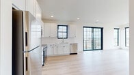 This thoughtfully designed 2-bedroom, 2-bathroom unit in Ankeny, Iowa offers a clean, contemporary aesthetic throughout. The open-concept kitchen and living area serves as the heart of the home, featuring white shaker cabinetry, white quartz countertops, a classic subway tile backsplash, and a full suite of stainless steel appliances including a refrigerator, range, built-in microwave, and dishwasher. Light wood-tone flooring runs throughout, enhancing the bright, airy feel of the space. Striking black-framed floor-to-ceiling glass sliding doors flood the living area with natural light and open directly onto a private balcony, offering outdoor views. The spacious primary bedroom includes a ceiling fan and generous closet space with sliding panel doors. Both bathrooms are finished with white vanities, quartz countertops, under-mount sinks, and backlit mirrors accented by matte black hardware fixtures, creating a polished, modern look. The second bedroom is equally well-proportioned with ample closet space. Additional conveniences include an in-unit laundry area and multiple closets for storage. The unit's crisp white walls, recessed lighting, and consistent modern finishes create a cohesive, fresh atmosphere throughout.