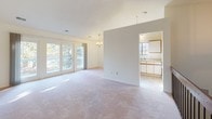 This single-floor, two-bedroom, one-bathroom residence in Midland, Michigan, offers a straightforward and functional layout designed for comfortable everyday living. The open living and dining area serves as the heart of the home, featuring soft carpeting, neutral walls, and sliding glass doors that invite abundant natural light and provide outdoor access. A chandelier adds a subtle decorative touch overhead, enhancing the bright, airy atmosphere of the space.

The kitchen is efficiently designed in a galley-style configuration, featuring white cabinetry with wood-toned accents, a full suite of appliances including an electric range and dishwasher, and tile flooring. A pass-through view connects the kitchen to the living area, maintaining an open feel throughout. An arched window near the staircase landing further contributes to the natural light within the space.

Both bedrooms are generously proportioned, carpeted, and finished with clean white walls. Large windows allow sunlight to fill each room, creating a warm and inviting environment. Wood-toned closet doors provide practical storage in the bedrooms.

The full bathroom features tile flooring, a tub and shower combination with sliding glass doors and tiled surround, a vanity with a wide mirror, and ample counter space, delivering a clean and functional design.
