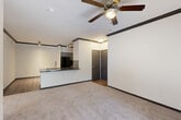 This 2-bedroom, 2-bathroom single-floor residence in Houston, TX offers a well-organized layout with a welcoming entrance that flows into a spacious open-concept living, dining, and kitchen area. The living room features plush carpet, crown molding with dark accents, a ceiling fan, and French doors that invite natural light and outdoor views. The kitchen is equipped with gray cabinetry, dark granite countertops, a striking black subway tile backsplash, black appliances, and wood-look flooring, complemented by a peninsula with a sink that connects seamlessly to the dining area. A dedicated pantry adds practical storage. A hallway leads to both bedrooms, each offering carpet flooring, ceiling fans, and natural light from large windows with blinds. The primary bedroom is generously sized with multiple windows on two walls, filling the room with light. Both bathrooms are clean and functional, with one featuring a tiled tub-shower combination and wood-look flooring. The unit also includes a dedicated laundry area and four closets throughout, providing exceptional storage. Crown molding and consistent dark trim details lend a cohesive, polished aesthetic throughout the entire residence.