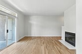 Located at 2235 Treehouse Lane in Corona, CA, this two-story, 2-bedroom, 2-bathroom home is thoughtfully laid out across two well-proportioned floors. The main level features an open-concept living and dining area anchored by a clean-lined fireplace with a white surround and warm wood-look flooring that flows throughout. A pass-through kitchen overlooks the living space and is equipped with white cabinetry, granite countertops, a stainless steel refrigerator, and an undermount sink. Sliding glass doors lead to a private balcony with leafy outdoor views, filling the main floor with natural light. Upstairs, the primary bedroom is generously sized with vaulted ceilings, a ceiling fan, an arched window, and direct access to a walk-in closet with built-in wire shelving. Its en-suite bathroom features dual granite-topped vanities, wood-look flooring, and a tub-shower combination. A second bedroom and full bathroom with a tub-shower are also found on this level. Additional highlights include two closets, a dedicated laundry area, a hallway, and a second balcony. The home's neutral palette and clean finishes create a bright, move-in-ready atmosphere throughout.