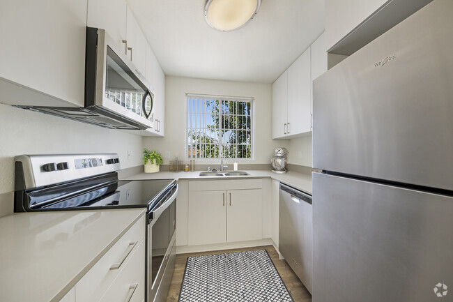 Upgraded Package kitchen with white cabinetry, grey quartz countertops, stainless steel appliances, upgraded lighting and fixtures, and hard surface flooring throughout - eaves La Mesa