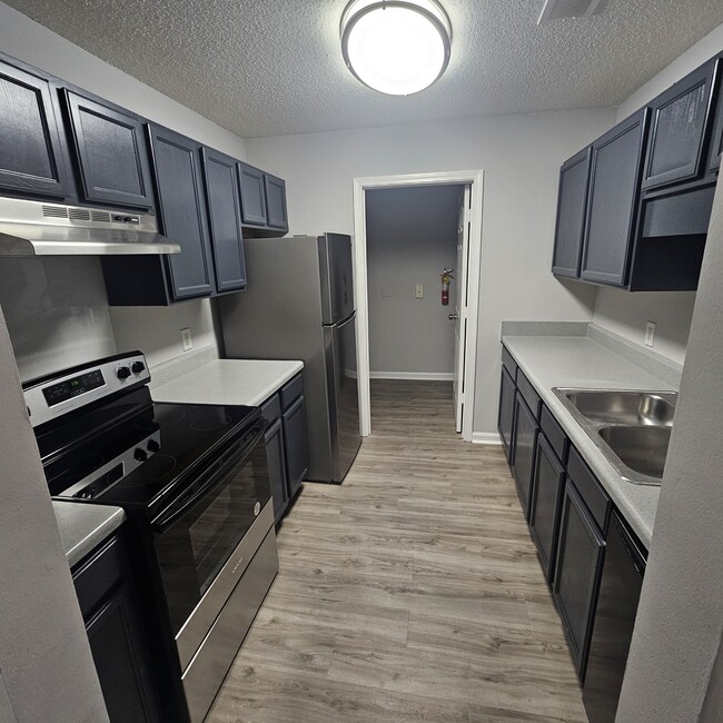 fully renovated kitchen with laundry nook - Evangeline Heights Apartments