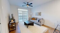 Located at Wesley Place in Indianapolis, Indiana, this single-floor residential unit offers a thoughtfully designed layout with modern finishes and a bright, clean aesthetic throughout. The open-concept living area features warm hardwood-style flooring, a ceiling fan with lighting, and a large sliding glass door fitted with vertical blinds that opens to a private balcony, allowing abundant natural light to fill the space. The kitchen is well-appointed with white shaker-style cabinetry, granite-look countertops, stainless steel appliances including a range, microwave, dishwasher, and refrigerator, along with a spacious peninsula with bar seating — ideal for both everyday cooking and casual dining. The bedroom is carpeted for comfort, features a double-door closet providing generous storage, and is brightened by a window with outdoor views. The bathroom is finished with white cabinetry, granite-look countertops, hardwood-style flooring, and a full tub-shower combination with tile surround. Clean white walls and consistent, contemporary finishes unify the space, creating a cohesive and inviting atmosphere suited for modern living in the heart of Indianapolis.