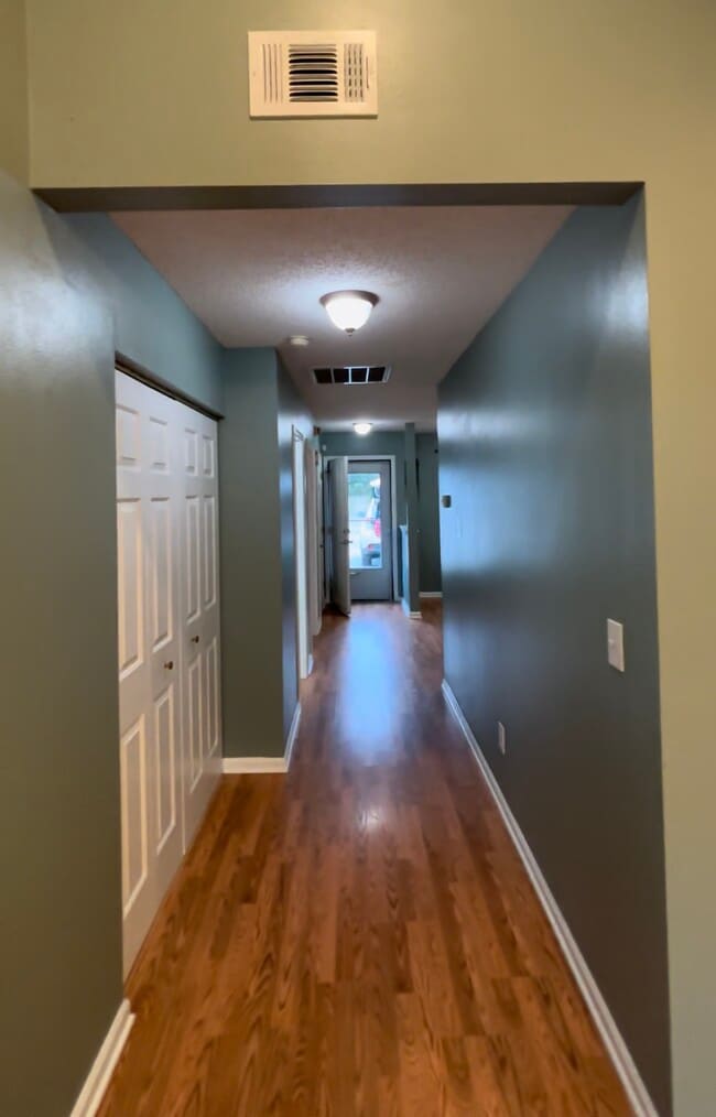Main hallway looking towards front door. Washer/dryer in utility closet to left - 1208 Apex Ln