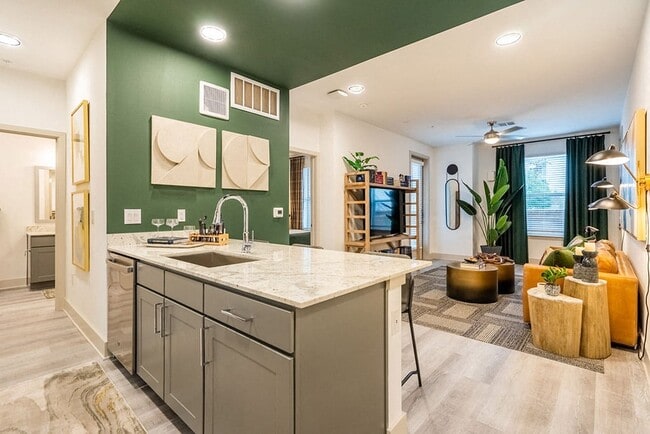 Una cocina moderna con una pared verde y una encimera de mármol. - Alta Sergeant