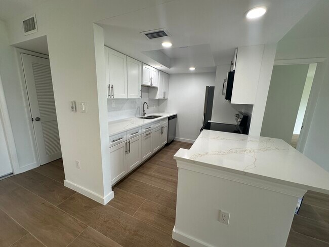 Brand new kitchen with new quartz countertops, custom cabinetry and all new appliances. - 2223 NW 22nd Ave