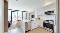 Located in the heart of San Diego at 1401 Union St, this sophisticated single-floor residence offers a seamlessly designed open-concept layout filled with abundant natural light. Floor-to-ceiling windows and sliding glass doors frame sweeping views of the downtown San Diego skyline, creating a dramatic backdrop throughout the living spaces.

The kitchen is a standout, outfitted with crisp white shaker cabinetry extending to the ceiling, quartz countertops, stainless steel appliances including a gas range, dishwasher, microwave, and refrigerator, and a peninsula with pendant lighting — ideal for both meal preparation and casual dining.

The living area is anchored by expansive glazed walls that open to a private balcony, flooding the space with daylight and providing panoramic city views. Warm-toned accent walls and herringbone-patterned flooring lend texture and character to the room.

The bedroom continues the floor-to-ceiling window theme, offering direct balcony access and a walk-in closet. The bathroom features a clean, modern aesthetic with a marble-look quartz vanity, matte black fixtures, white shaker cabinetry, and a walk-in shower with tile surround.

Light wood-tone flooring flows throughout, tying together the contemporary design. This residence delivers a refined urban living experience with high-end finishes and exceptional city views.