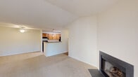 Located at Lake Club Court in Charlottesville, Virginia, this single-floor residence offers four bedrooms and two bathrooms within a well-organized layout. The living room serves as the focal point of the home, featuring vaulted ceilings that lend a sense of openness and a wood-burning fireplace framed by a sleek dark surround. French doors along one wall invite natural light while providing access to an outdoor balcony with views of surrounding greenery. Neutral carpet throughout the living and bedroom areas contributes to a cohesive, comfortable ambiance.

The galley-style kitchen is efficiently designed with warm wood cabinetry, granite-look countertops, light wood-style flooring, and black appliances including a range and refrigerator. A peninsula with a pendant light and double sink connects the kitchen to the living area, creating an open, functional flow.

The bedrooms are carpeted and bright, with the primary bedroom featuring a ceiling fan and a window with outdoor views. Additional bedrooms offer ample space and closet access. Two full bathrooms include standard tub-shower combinations. A dedicated laundry room houses a full-size washer and dryer, adding everyday convenience to this well-appointed Charlottesville residence.