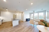 Located at 1700 Katy Fort Bend Road in Katy, TX, this single-story, one-bedroom unit offers a thoughtfully designed layout that maximizes its footprint. The open-concept kitchen is a standout feature, showcasing white shaker cabinetry, stainless steel appliances including an electric range and refrigerator, a marble-style tile backsplash, and a large center island with a quartz countertop and bar seating — ideal for both meal preparation and casual dining. Built-in open shelving adds a stylish and functional touch to the kitchen area, along with a dedicated desk nook. Light wood-look flooring flows throughout the main living areas, lending a clean and cohesive aesthetic. The living room is bright and welcoming, anchored by large windows and a glass door that open to outdoor views of the surrounding greenery, filling the space with natural light. A ceiling fan adds comfort to the room. The bedroom features plush carpeting, a ceiling fan, and generous windows with views of the outdoor landscape, creating a calm and restful retreat. A dedicated closet provides practical storage. Hallways connect the spaces efficiently, contributing to the unit's smart and functional flow throughout.