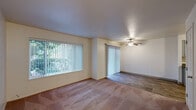 This single-floor, 2-bedroom, 1-bathroom residence in Woodland, WA offers a practical and comfortable layout with a well-considered mix of rooms. The living room is generously proportioned, featuring plush carpeting, a ceiling fan, large windows with vertical blinds, and a sliding glass door that leads to a private patio, filling the space with natural light and views of surrounding greenery. Adjacent to the living room, the dining area flows seamlessly into the home's common spaces. The kitchen is well-equipped with white cabinetry, gray countertops, wood-look flooring, and black appliances including an electric range, dishwasher, and refrigerator. Both bedrooms are carpeted and include ceiling fans and closets with bifold doors; the primary bedroom benefits from dual windows that invite ample natural light. The full bathroom features a tub/shower combo, a vanity with gray countertop, and wood-look flooring consistent with the kitchen. Additional highlights include three closets for abundant storage, a dedicated laundry area, baseboard heating throughout, and a welcoming entrance. The overall ambiance is clean, bright, and functional.