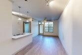 Located at 5451 Fulton St in Houston's 77009 zip code, this two-bedroom unit offers a well-designed single-level floor plan with a thoughtful mix of hard and soft flooring throughout. The open-concept main living area seamlessly connects the kitchen, dining, and living spaces under crown molding-trimmed ceilings equipped with track lighting and a ceiling fan. The kitchen features taupe cabinetry, a tile backsplash, black appliances, and a granite-topped peninsula with a double-basin sink and elegant pendant lighting — ideal for both cooking and casual dining. A door from the living area leads directly to a private balcony, allowing natural light to fill the space. The primary bedroom is carpeted and includes a ceiling fan, an en-suite bathroom with dark wood vanity cabinetry, and access to a spacious walk-in closet with built-in shelving and dual hanging rods. The second bedroom is also carpeted, features a ceiling fan, and benefits from two large windows with outdoor views. Additional highlights include two closets, a dedicated laundry area, and light wood-tone flooring in the main living spaces that adds warmth and continuity throughout the home.