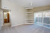 Located at 3597 S Zeno Way in Aurora, CO, this single-floor, 2-bedroom, 2-bathroom home offers a well-organized and functional layout. The open-concept living, dining, and kitchen area serves as the heart of the home, with soft carpet underfoot in the living space and a sliding glass door that fills the room with natural light and provides outdoor access. A set of built-in corner shelves adds a distinctive architectural detail, offering practical display and storage space. The kitchen features warm honey-toned wood cabinetry, a tiled mosaic backsplash, wood-look flooring, and black appliances including a refrigerator, range, and over-the-range microwave. Both bedrooms are carpeted and finished in neutral tones, offering comfortable, quiet retreats. The spacious primary bedroom includes a generous walk-in closet equipped with dual shelving systems for ample organization. The two bathrooms each feature wood-look tile flooring, a tub-shower combo with tiled surround, and warm wood vanity cabinetry with light countertops. Additional highlights include a dedicated laundry area, a utility room, a hallway connecting the main spaces, and four total closets throughout, ensuring excellent storage capacity across the entire home.