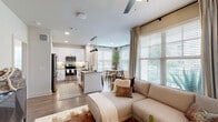 Located at 1400 N Main St in Keller, TX, this thoughtfully designed 2-bedroom, 2-bathroom residence offers a comfortable and functional single-floor layout. The open-concept living area seamlessly connects the kitchen, dining room, and living room, creating an inviting space ideal for both everyday living and entertaining. Large windows bathe the area in natural light, while ceiling fans add to the airy atmosphere.

The kitchen is equipped with stainless steel appliances, white shaker cabinetry, a subway tile backsplash, dark countertops, and a central island with a deep sink — a practical and stylish hub for cooking. Adjacent to the kitchen, the dining nook is framed by a bay of windows with outdoor views, providing a bright and pleasant setting for meals.

The living room features a ceiling fan, large windows with curtains and blinds, and wood-look flooring that extends throughout the main areas. A well-lit hallway connects the bedrooms, each offering walk-in closet storage. The primary bedroom includes a dedicated closet and a window overlooking the outdoors. The primary bathroom features a double-sink vanity with dark countertops, a glass-enclosed shower, and a separate soaking tub. The unit also includes an in-unit laundry area for added convenience.