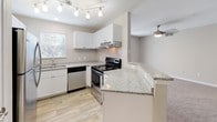 Located at 222 Old Fayetteville Road in Carrboro, NC, this single-floor unit offers a well-organized layout designed for comfortable everyday living. The entryway welcomes you with tile flooring and clean, neutral-toned walls that carry throughout the home. The open-concept kitchen is equipped with stainless steel appliances, white cabinetry, granite countertops, a tile backsplash, and track lighting overhead. A peninsula counter connects seamlessly to the living area, which features plush carpeting, a ceiling fan with light fixture, and sliding glass doors that open to a private balcony with outdoor views. A dedicated dining area sits nearby, illuminated by an elegant chandelier. The bedrooms are carpeted and bathed in natural light through blinded windows, each offering generous wall space and closet access. The bathrooms are finished with wood-look vinyl flooring, granite vanity countertops, white cabinetry, and a tiled shower-tub combination. Textured ceilings and consistent neutral paint tones create a cohesive, calm ambiance throughout the unit, while the thoughtful floor plan ensures functional flow between all living spaces.