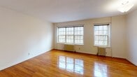 Located on Clinton Avenue in the heart of Minneapolis, MN, this single-floor residence showcases a blend of classic architectural character and functional design. Throughout the living areas, warm-toned hardwood floors gleam underfoot, adding richness and continuity to the space. A standout architectural detail is the graceful arched doorway that connects rooms, lending an elegant, timeless quality to the interior.

The living areas are generously proportioned, with crisp white walls and large multi-pane windows that allow abundant natural light to pour in, framing views of the surrounding neighborhood's mature trees. Vintage cast-iron radiators beneath the windows speak to the building's historic character while providing efficient heating throughout the colder Minneapolis seasons.

The bathroom is finished with classic white square tile surrounding the bathtub and shower area, complemented by a window that allows for natural ventilation and light. The neutral palette throughout the unit creates a clean, versatile backdrop ready for personalization.

The overall ambiance of this space is warm and inviting, with a nod to traditional design elements that give it a distinctive character. The combination of hardwood floors, arched passageways, and period-appropriate details make this a space that feels both historic and comfortable.