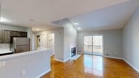 Located at 30 Pasture Trail in Somerset, NJ, this well-appointed 2-bedroom, 2-bathroom single-floor home offers a thoughtfully designed layout with warm hardwood flooring throughout the main living areas and bedrooms. The living room is a standout space, featuring soaring vaulted ceilings, recessed lighting, and a tile-surround fireplace that anchors the room. Sliding glass doors open to a private balcony with views of surrounding trees, filling the space with natural light. The kitchen is efficiently laid out with dark cabinetry, white countertops, and a full suite of stainless steel appliances, including a refrigerator, gas range, and over-the-range microwave. In-unit laundry is conveniently accessible from the main corridor. The generously sized primary bedroom includes a dedicated closet and direct access to a bathroom. Both bathrooms are cleanly finished — one features dark tile flooring, a white vanity, and a tub/shower combo, while the second offers white subway tile wainscoting. The second bedroom is bright and comfortably proportioned with the same rich hardwood flooring. Neutral gray walls throughout lend the home a cohesive, move-in-ready aesthetic.