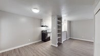 Located in Dallas, TX, this single-story home at 2702 Arroyo Ave offers a thoughtfully updated interior with a clean, modern aesthetic throughout. The open-concept living and dining area features durable wood-look flooring, neutral gray walls, and a textured ceiling, creating a bright and cohesive atmosphere. A built-in shelving unit serves as a stylish divider between the living space and kitchen, adding both character and functional storage. The galley-style kitchen is well-appointed with white cabinetry, a tile backsplash, black appliances including an electric range and refrigerator, and a window that allows natural light to fill the space. A pendant light adds a modern touch above the adjoining dining area. The bedrooms are carpeted for comfort and feature ceiling fans, ample closet space with double built-in closets, and windows with natural light. The bathroom is finished with a dark granite countertop, white cabinetry, a framed mirror, and a tiled tub-shower combination, offering a polished, cohesive design. The 3D floorplan reveals a practical and well-organized layout that maximizes the available space across the single floor, making this home both functional and inviting.