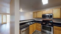Located at 970 Spring Forest Rd in Greenville, NC, this single-floor unit offers a well-designed, functional layout ideal for comfortable everyday living. The kitchen is a standout feature, equipped with stainless steel appliances including a range, microwave, and dishwasher, complemented by warm oak cabinetry and dark countertops. A breakfast bar provides a seamless transition between the kitchen and the adjacent living area, making the space feel open and connected. Throughout the main living and bedroom areas, durable hardwood-style flooring adds a clean, modern aesthetic, while textured ceilings and ceiling fans contribute to a relaxed, comfortable ambiance. The living area benefits from natural light and includes a door that opens to an outdoor area, further enhancing the sense of space. The bathroom features a wood-toned vanity with ample cabinet storage, a large mirror, and a shower/tub combination. A dedicated utility area houses a Rheem water heater alongside laundry hookups with wire shelving for additional storage. Natural light flows through several windows, and ceiling fans in the main rooms promote air circulation throughout the home. The thoughtful single-level layout ensures easy accessibility and a cohesive flow from room to room.