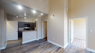 Located at 2200 Bellamy Dr in Greenville, NC, this two-story residence offers a thoughtfully designed layout with a range of practical and comfortable features throughout. The main level impresses immediately with dramatically high ceilings that lend an open, airy quality to the living area. Rich hardwood-style flooring runs throughout, adding warmth and visual continuity across both floors. The kitchen is equipped with dark cabinetry, stone-look countertops, and a full suite of black appliances including a refrigerator, electric range, and over-the-range microwave, complemented by a convenient breakfast bar. A half bathroom on the main level features a dark vanity with a countertop sink and hardwood-style flooring. A staircase with clean white railings and natural light from upper windows leads to the second floor. Upstairs, the bedrooms are well-proportioned, each with hardwood-style flooring and ceiling fans with light fixtures. The upper-level bathroom features a dual-sink vanity with stone-look countertops and large mirrors. A dedicated laundry room with a full-size washer and dryer adds everyday convenience. Neutral warm-toned walls throughout create a cohesive and inviting atmosphere across the entire space.