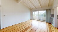 Located at 974 Haverford Ave in the desirable Pacific Palisades neighborhood of Los Angeles, this thoughtfully designed studio offers a compact yet efficient layout across a single floor. The living area immediately impresses with soaring vaulted ceilings accented by exposed white-painted wood beams, creating a sense of openness well beyond the unit's footprint. Warm, wide-plank hardwood floors run throughout, adding natural character and continuity to the space. Sliding glass doors in the living area open directly onto a private balcony, flooding the interior with natural light and offering pleasant views of the surrounding treetops and neighborhood. Two mirrored sliding-door closets provide ample storage while visually expanding the room. The kitchen is efficiently arranged with white cabinetry, tile countertops with a classic red accent trim, a stainless steel refrigerator, and a gas range, all set atop the same hardwood flooring. The bathroom features floor-to-ceiling white tile in the tub and shower enclosure, a wood-toned vanity, and a clean, bright finish. The overall ambiance is airy and light-filled, with a clean, minimalist aesthetic complemented by the warm tones of the natural wood floors throughout.