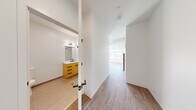 Located at 43 Braintree St in Boston's Allston neighborhood, this efficiently designed single-floor unit offers a thoughtfully laid-out living space with contemporary finishes throughout. Light hardwood-style flooring flows seamlessly from the entrance through the main living area, creating a cohesive and clean aesthetic.

The kitchen is outfitted with flat-front white lower cabinetry paired with warm wood-toned upper cabinets, a white tile backsplash, and a built-in cooktop with an under-cabinet range hood. Stainless steel appliances, including a full-size refrigerator and dishwasher, complete the functional setup. A window at the end of the living area floods the space with natural light and offers views of the surrounding Boston cityscape.

The entrance corridor provides access to an in-unit washer, electrical panel, and additional storage closets, maximizing the efficiency of the layout. The bathroom features a warm wood-toned vanity with a white quartz countertop, a large mirror, and a fully tiled walk-in shower with matte black fixtures — a refined, modern touch. Tile flooring in the bathroom contrasts neatly with the wood-style flooring in the rest of the unit.

Overall, the space presents a clean, modern aesthetic with carefully selected materials and a functional floor plan well-suited for urban living.