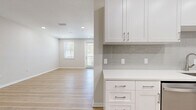 Located at 605 4th Avenue Northwest in Largo, FL, this thoughtfully designed one-bedroom, one-bathroom home offers a clean, modern aesthetic throughout its efficiently utilized single-floor layout. Light-toned hardwood flooring flows seamlessly through every room, contributing to a bright and cohesive feel.

The kitchen is a standout feature, showcasing white shaker-style cabinetry with brushed nickel hardware, crisp white quartz countertops, and a soft gray subway tile backsplash. Stainless steel appliances — including a range, microwave, and dishwasher — complete the well-appointed space. The kitchen opens directly into the combined living area, creating an airy, open-concept atmosphere ideal for everyday living.

The living room receives natural light through multiple windows fitted with blinds, and a glass-paneled entry door further enhances the brightness of the space. Recessed lighting throughout provides consistent, even illumination.

The bedroom is a comfortable, well-proportioned room featuring a window with an outdoor view, recessed lighting, and a closet with bi-fold doors. Additional storage is available via a dedicated closet space in the unit.

The bathroom is clean and simply designed, with a white vanity and coordinating fixtures consistent with the home's modern palette. A laundry area with washer and dryer hookups is also present, adding everyday convenience to this move-in-ready home.