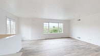 This three-floor home is designed with a clean, contemporary aesthetic, characterized by bright white walls, light-toned wood-look flooring, and an abundance of natural light throughout. The main living area is open and airy, featuring large windows that frame lush, green outdoor views, creating a seamless connection between the interior and the surrounding landscape.

The kitchen is well-equipped and thoughtfully designed, showcasing cream-toned cabinetry with detailed millwork, striking dark granite countertops, a deep double sink, and a full suite of stainless steel appliances. A staircase with an elegant white frame and dark metal balusters connects the floors, adding a refined architectural detail to the home's interior.

Upper-level bedrooms are carpeted for comfort and include generous walk-in closets fitted with wire shelving systems. A ceiling fan and wide windows with verdant views enhance the sense of space in the primary bedroom. Bathrooms are finished with marble-style tile, dark granite vanity tops, white cabinetry, and glass-enclosed tub-shower combinations with brushed gold hardware.

The lower level includes a spacious attached two-car garage with an automatic opener, a dedicated laundry room with utility sink, built-in shelving, and all necessary hookups, rounding out this functional and well-appointed home.