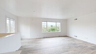This three-floor home is designed with a clean, contemporary aesthetic, characterized by bright white walls, light-toned wood-look flooring, and an abundance of natural light throughout. The main living area is open and airy, featuring large windows that frame lush, green outdoor views, creating a seamless connection between the interior and the surrounding landscape.

The kitchen is well-equipped and thoughtfully designed, showcasing cream-toned cabinetry with detailed millwork, striking dark granite countertops, a deep double sink, and a full suite of stainless steel appliances. A staircase with an elegant white frame and dark metal balusters connects the floors, adding a refined architectural detail to the home's interior.

Upper-level bedrooms are carpeted for comfort and include generous walk-in closets fitted with wire shelving systems. A ceiling fan and wide windows with verdant views enhance the sense of space in the primary bedroom. Bathrooms are finished with marble-style tile, dark granite vanity tops, white cabinetry, and glass-enclosed tub-shower combinations with brushed gold hardware.

The lower level includes a spacious attached two-car garage with an automatic opener, a dedicated laundry room with utility sink, built-in shelving, and all necessary hookups, rounding out this functional and well-appointed home.