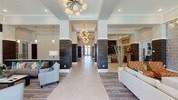 Located at 3000 Dominion Ridge Way in Morrisville, NC, this single-floor clubhouse is a masterfully designed community amenity space that blends contemporary style with functional versatility. The grand entrance corridor sets an impressive tone, featuring a herringbone-patterned tile floor, dark wood-clad columns, and a series of elegant sputnik chandeliers that draw the eye through the length of the hall toward glass double doors beyond.

The main lounge areas are bathed in natural light from floor-to-ceiling windows overlooking the outdoor pool area, with direct access through glass doors. Plush sectional and accent seating arrangements are complemented by built-in shelving, a marble-surround fireplace, and rich layered textures throughout.

The game room stands out with a full-size billiards table positioned beneath a striking teal geometric ceiling feature and bold pendant lighting, alongside a wet bar with a mounted flat-screen TV. A dedicated social lounge offers upholstered banquette seating, marble-top tables, gold pendant lights, and a multi-screen TV wall, perfect for gatherings.

The event kitchen and dining area features bold hexagonal tile flooring, a large stone-topped communal table with teal velvet seating, dark shiplap accent walls, and a fully equipped catering-style kitchenette.