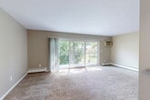 Located at 31200 Morlock St in Livonia, Michigan, this one-bedroom, one-bathroom unit offers a well-organized single-floor layout designed to maximize functionality. The living room is a bright, open space finished with plush wall-to-wall carpeting and neutral tan walls. Large sliding glass doors flood the room with natural light and provide direct access to a private balcony overlooking mature, leafy trees — creating a serene outdoor retreat. Baseboard heating runs along the perimeter, and a wall-mounted air conditioning unit ensures year-round comfort.

The dining room flows naturally from the living area, anchored by a pendant light fixture that adds a touch of warmth. The galley-style kitchen features light tile flooring, white cabinetry, granite-look countertops, a stainless steel sink, and stainless steel appliances including a refrigerator, dishwasher, and microwave. A pass-through counter connects the kitchen to the dining space, enhancing the open feel.

The bedroom is a quiet, carpeted room with a large window dressed in vertical blinds that invite natural light while maintaining privacy. Three closets throughout the unit provide ample storage. A hallway connects all rooms efficiently, completing this thoughtfully laid-out Livonia residence.