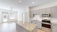 Located in Garland, TX, this 2-bedroom, 2-bathroom residence offers a clean, modern design across a single floor. The open-concept kitchen is a standout feature, showcasing gray shaker-style cabinetry, a white subway tile backsplash, granite countertops, and a central island. Stainless steel appliances — including a refrigerator, range, microwave, and dishwasher — complete the space, which flows naturally into the living area. Light wood-style flooring runs throughout the main living areas, lending a warm, cohesive feel.

The living room benefits from natural light streaming through windows and a glass door that opens to a private outdoor area, enhanced by a ceiling fan overhead. Both bedrooms are carpeted and bright, with large windows that invite ample natural light. The generously sized primary bedroom includes its own bathroom and a walk-in closet with built-in shelving for organized storage. The second bedroom is equally comfortable, with its own well-sized closet nearby.

The bathrooms are finished with clean white tile, a soaking tub with overhead shower, and wood-style flooring. Two dedicated closets provide practical storage throughout. The overall ambiance is light, airy, and move-in ready, with a neutral color palette that suits a variety of personal styles.