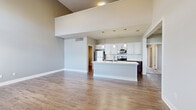 Located in New Albany, Ohio, this two-bedroom, two-bathroom two-story home offers a well-designed layout spread across two generously sized floors. The main level opens into a bright, open-concept living and kitchen area finished with warm hardwood-style flooring and soaring ceilings that enhance the sense of space. The kitchen is a standout feature, showcasing white shaker cabinetry, rich dark lower cabinets, a white quartz waterfall island with an undermount sink, subway tile backsplash, and stainless steel appliances illuminated by stylish pendant lighting. A dedicated laundry room adjacent to the kitchen includes upper cabinetry, a quartz countertop, and full-size washer and dryer hookups. Upstairs, the bedrooms are carpeted for comfort. The primary bedroom includes a spacious walk-in closet outfitted with wire shelving and basket storage. The second bedroom features multiple windows that invite abundant natural light. An additional room with a sloped ceiling and carpet offers versatile use as a bonus or flex space. Both bathrooms are finished with wood-style flooring, white vanities, and a glass sliding shower enclosure. Three closets throughout the home provide ample storage. The neutral color palette and clean finishes create a cohesive, move-in-ready aesthetic throughout.