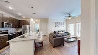 Located at 102 Cool Springs Dr in Elizabethtown, KY, this well-appointed apartment offers three bedrooms, two bathrooms, and a thoughtfully designed single-floor layout. The open-concept living and kitchen area serves as the heart of the home, featuring wood-look flooring, crown molding, and a ceiling fan. The kitchen is equipped with dark espresso cabinetry, granite countertops, stainless steel appliances including a refrigerator, range, and microwave, along with a peninsula island with bar seating and pendant lighting. A separate dining area accommodates a full table beneath a stylish chandelier. The living room opens to the outdoors via French doors, allowing generous natural light to fill the space. The primary bedroom is a comfortable retreat with plush carpeting and a ceiling fan, while the additional bedrooms share the same warm, carpet-floored aesthetic. Two bathrooms serve the unit — one featuring a soaking tub with shower combination and tile flooring, the other with a granite vanity, dark wood cabinetry, and wood-look flooring. Five closets throughout the unit provide ample storage. A dedicated in-unit laundry room houses a full-size washer and dryer, adding everyday convenience to this move-in-ready home.