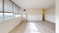 Located at 125 Neptune Dr in Toronto, this well-appointed 2-bedroom, 2-bathroom unit offers a clean, modern aesthetic throughout. Light wood-toned flooring runs continuously across the space, complementing the crisp white walls and creating a bright, airy atmosphere. The spacious living room is bathed in natural light from a large bank of windows, offering open city views and a welcoming sense of openness. An adjacent area connects seamlessly to the kitchen, which features white cabinetry with contemporary hardware, stone-look countertops, white subway tile backsplash, and stainless steel appliances including a refrigerator and electric range. The primary bedroom is generously sized, complete with a dedicated closet and a private ensuite bathroom featuring a tiled tub-shower combination. The second bedroom benefits from its own large window framing city views, with a sliding mirrored closet for ample storage. A second full bathroom with a tub-shower serves the remainder of the unit. A dedicated entrance provides a practical transition into the home. Both bedrooms and common areas receive excellent natural light throughout the day, contributing to the unit's clean, bright, and functional character.