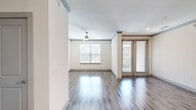 This single-floor residence offers a thoughtfully designed layout across two bedrooms and two bathrooms. The open-concept living and kitchen area serves as the heart of the unit, where durable hardwood-style plank flooring extends throughout the main spaces. The kitchen is a standout feature, equipped with dark espresso cabinetry, stainless steel appliances, a subway tile backsplash, pendant lighting, and a curved granite-topped island with an undermount sink. Recessed lighting and crown molding detail the ceiling, adding a polished finish. The living area benefits from multiple windows and a glass French door that invites natural light and outdoor views, complemented by a ceiling fan overhead.

The primary bedroom is generously proportioned, featuring plush carpet, a ceiling fan, and a dedicated window for natural light. It is served by a well-organized walk-in closet with built-in shelving and hanging systems. The second bedroom also offers hardwood-style flooring and a large window. Both bathrooms are finished with granite countertops, dark cabinetry, and tub-shower combinations set against clean white surrounds with wood-look tile flooring.