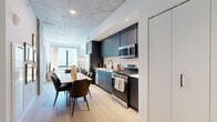 Located at 625 N 2nd Ave in the heart of Phoenix, AZ, this modern one-bedroom, one-bathroom residence offers a thoughtfully designed single-floor layout with contemporary industrial-chic character. The open-concept living, dining, and kitchen area serves as the centerpiece of the unit, anchored by striking exposed concrete ceilings that add an urban edge. Light wide-plank flooring flows throughout, complementing the bright, airy atmosphere created by floor-to-ceiling windows that frame sweeping views of the Phoenix skyline and fill the space with abundant natural light.

The kitchen features sleek dark cabinetry, white tile backsplash, stainless steel appliances including a gas range, and clean white countertops. A generous dining table sits adjacent, making the space ideal for both casual meals and entertaining. The living area benefits from the same dramatic window views and an open, relaxed layout.

The bedroom is a standout, showcasing a full exposed concrete accent wall that lends a distinctive, loft-inspired feel, complemented by natural light from a large window. Two closets offer ample storage. The bathroom is finished with a floating wood vanity, backlit mirror, and large-format tile flooring, delivering a clean, spa-like aesthetic. An in-unit laundry area completes this well-appointed urban residence.