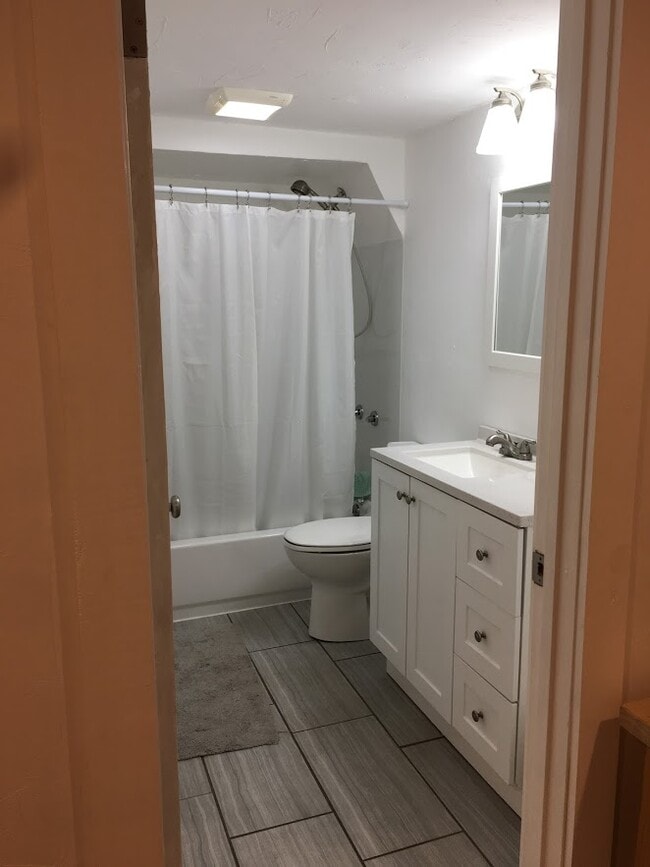 Full bathroom, recently remodeled with new flooring, cabinets and paint. - 2415 E 12th St
