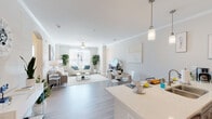 This well-appointed single-floor residence offers a thoughtfully designed open-concept layout that seamlessly connects the kitchen, dining, and living areas, creating a spacious and inviting atmosphere throughout. Light-toned luxury vinyl plank flooring runs through the main living spaces, complemented by crown molding and neutral walls that enhance the bright, airy feel.

The kitchen is a standout feature, outfitted with gray shaker-style cabinetry, a mosaic tile backsplash, stainless steel appliances including a refrigerator, range, microwave, and dishwasher, and a generous peninsula with a quartz countertop and bar seating for two. Pendant lighting adds a refined touch overhead. The open living room benefits from abundant natural light through large windows, a ceiling fan, and ample space for comfortable seating arrangements.

The residence includes two well-sized bedrooms, each with plush carpeting and generous natural light. The bathroom features a wide quartz vanity with gray cabinetry and a large mirror, offering both style and practicality. A dedicated in-unit laundry room with a full-size washer and dryer and overhead shelving rounds out the functional amenities of this clean, contemporary home.